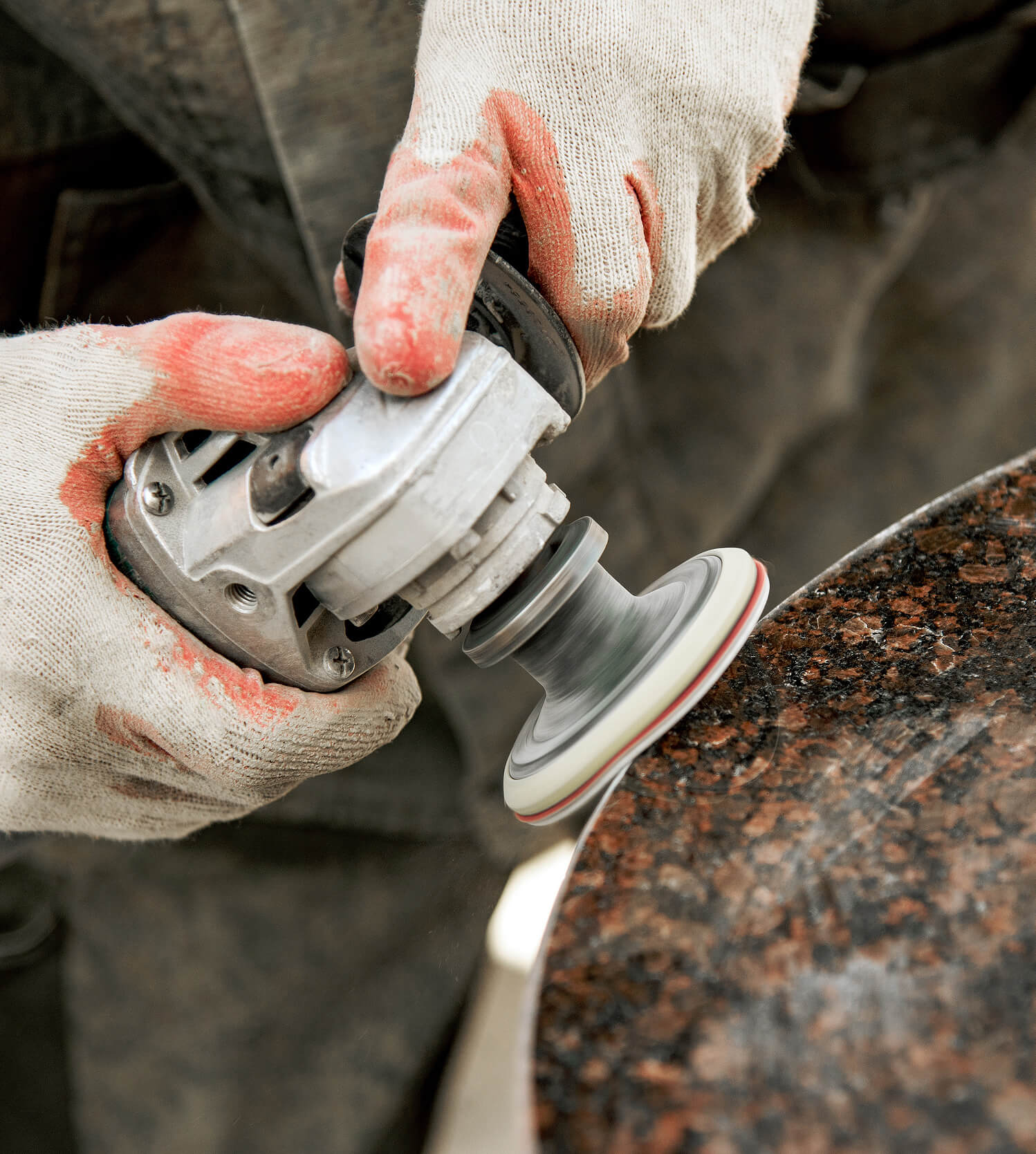 A machine operator working on a piece while silica dust is produced.