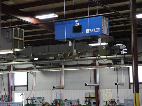 Blue Ox air filtration systems installed in a facility with open window ventilation.
