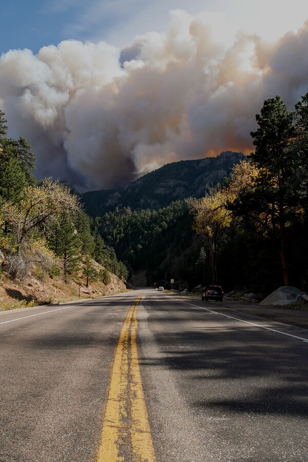 Smoke plume and flames from the peak to peak highway wildfire