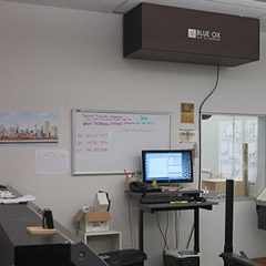 A Blue Ox OX1100-CC air cleaner in the color brown, shown installed above a work area at Canvas Print Shop.